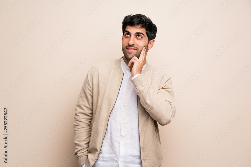 Young man over isolated wall thinking an idea while looking up Young man over isolated wall thinking an idea while looking up