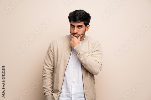 Young man over isolated wall thinking