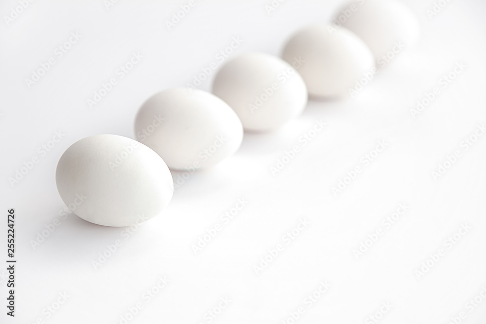 white chicken eggs lined up horizontally on a white background white chicken eggs lined up horizontally on a white background