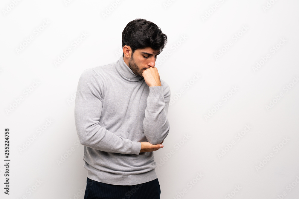 Young man over isolated white wall having doubts Young man over isolated white wall having doubts
