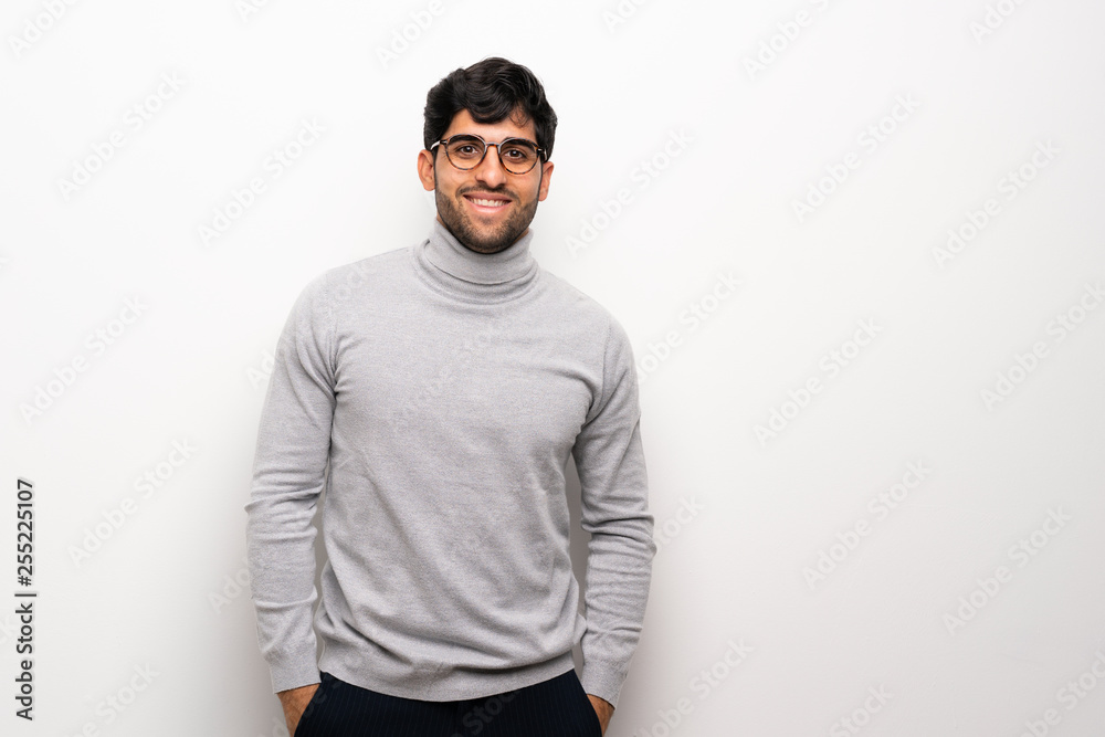Young man over isolated white wall with glasses and happy Young man over isolated white wall with glasses and happy
