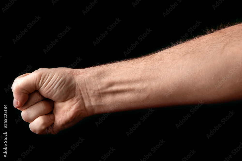 Fist isolated on black background. A strong man raised his fist on a black background, power, protest, fist ready for battle. Fist isolated on black background. A strong man raised his fist on a black background, power, protest, fist ready for battle.