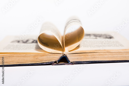 Opened book with pages made in the form of the heart, white background