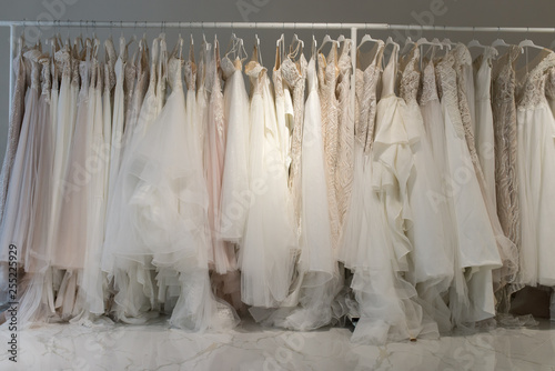 Wedding dresses hang on hangers. Factory of wedding dresses. photo
