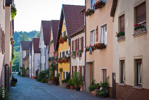 A narrow street with beautiful bright houses and flowers on it. Veitshoechheim  Germany