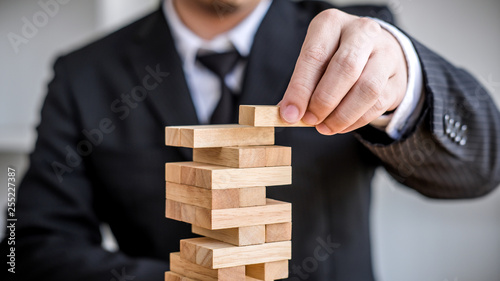Alternative risk concept, plan and strategy in business, Risk To Make Business Growth Concept With Wooden Blocks, Images of hand of business people placing and pulling wood block on the tower