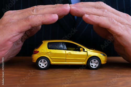 Insurance agent is protecting car. Concept of auto insurance.
