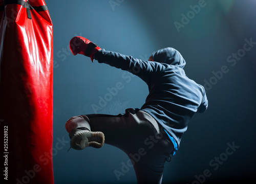 The young man workout a kick on the punching bag