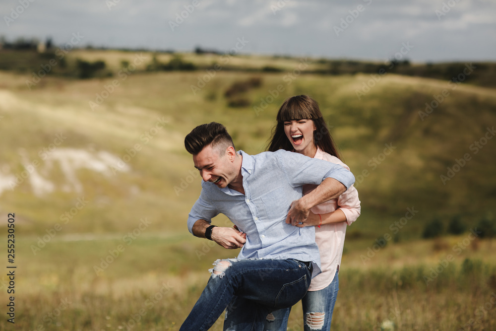 crazy young couple emotionally having fun, kissing and hugging outdoors. Love and tenderness, romance, family, emotions, fun. having fun together crazy young couple emotionally having fun, kissing and hugging outdoors. Love and tenderness, romance, family, emotions, fun. having fun together