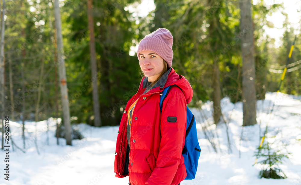 Young sports woman in a warm winter clothes in the winter forest in Finland