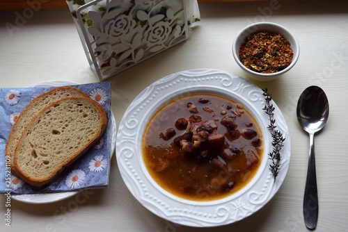 Homemade bean soup , vegetables ,bacon and spices. Detail of bowl of bean soup with large beans photo