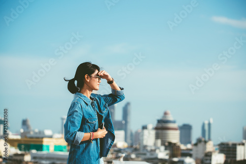 Quadro su tela Portrait of a relaxed Asian woman looking forward at the horizon cityscape in th