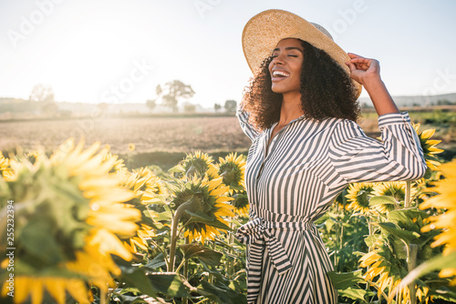 Happy young black woman in a sunflower field