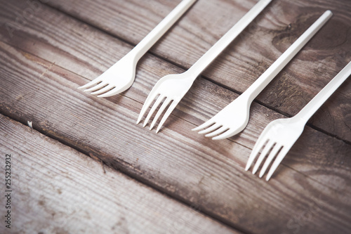 Plastic forks on wooden background,  plastic free concept