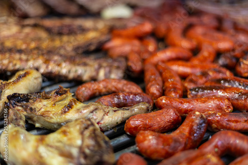 Pork ribs and sausages grilled in a barbecue