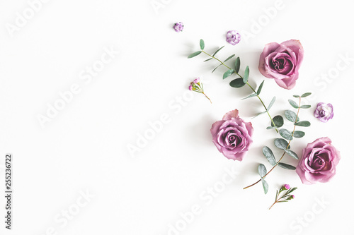 Flowers composition. Pattern made of eucalyptus branches and rose flowers on white background. Flat lay, top view, copy space