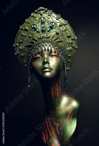 Black head of mannequin in decorated green kokoshnick, dark studio background