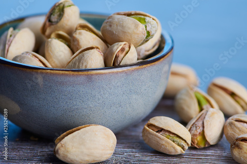 ceramic bowl with roasted and salted pistachios, macro photo