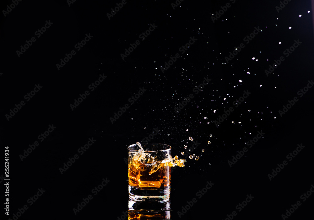 whiskey with splash on black background, brandy in a glass whiskey with splash on black background, brandy in a glass