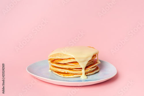 Pancakes with condensed milk or cream sauce on a blue plate