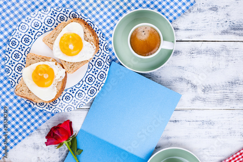 Flowers, Two cups of aromatic coffee and heart-shaped toasts for a romantic morning of lovers. Red rose, letter or note on the table. The concept of Valentine's Day and Mother's Day. Flat lay.  photo