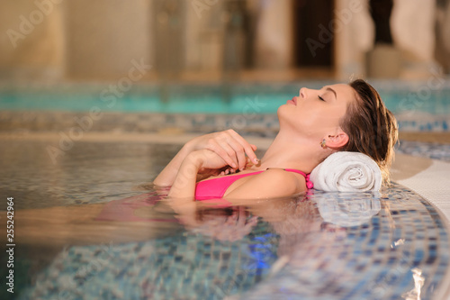 lateral view of a beautiful woman wearing swimsuits relaxing in swimming pool