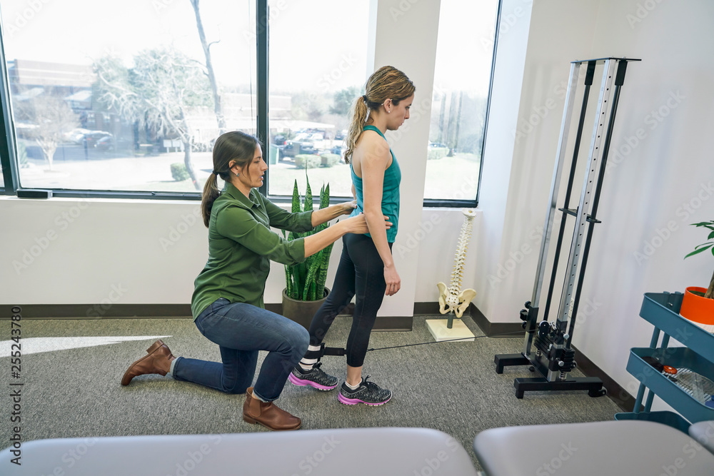 Physiotherapist assisting her patient during exercise Physiotherapist assisting her patient during exercise