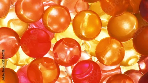 Bright orange hydrogel balls closeup, rotation