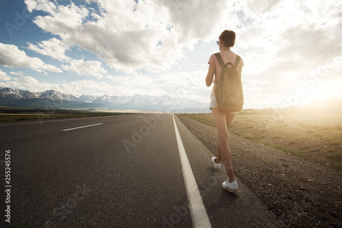 Woman backpacker travel outdoor. Mountains at background.