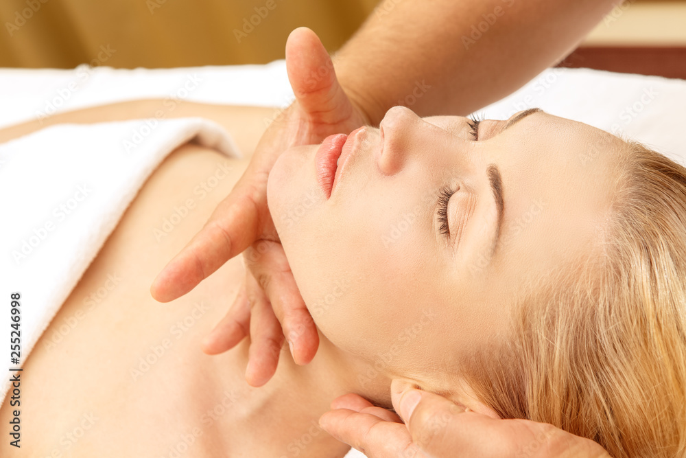 Face skin treatment. Close up shot of a relaxing woman getting face massage in SPA center