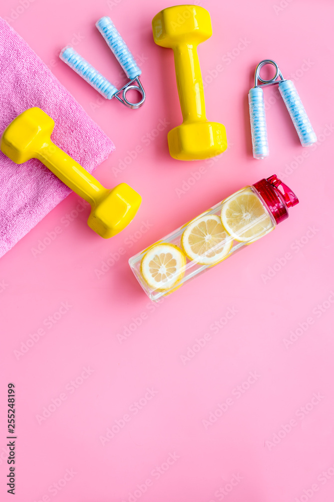 Fitness background with sport equipment for gym and home on pink background top view copyspace