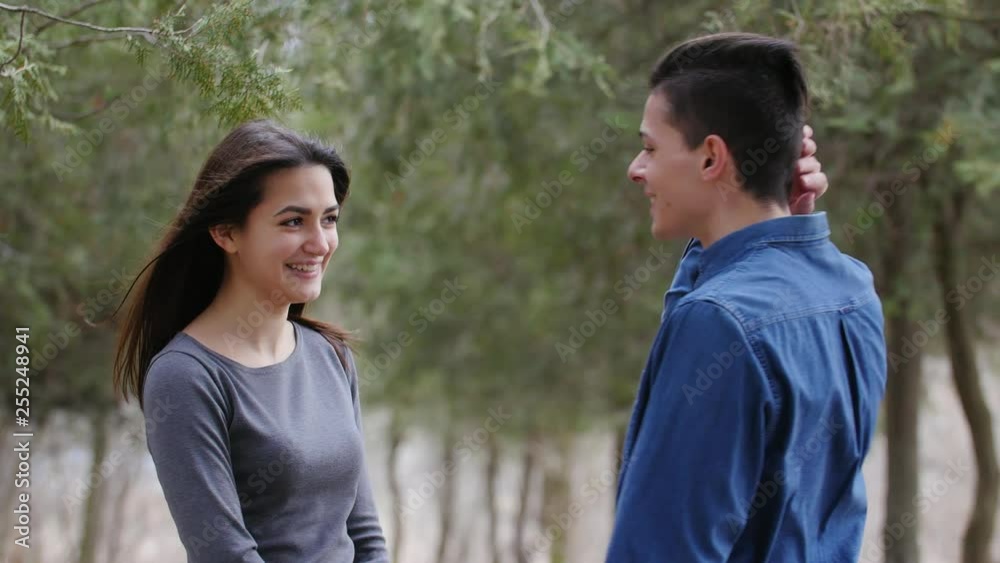 awesome cute young caucasian woman calls her boyfriend for kisses in a park in windy cold weather awesome cute young caucasian woman calls her boyfriend for kisses in a park in windy cold weather