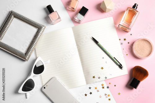 Flat lay composition with blank notebook, cosmetics and phone on color background, space for text. Blogger's workplace