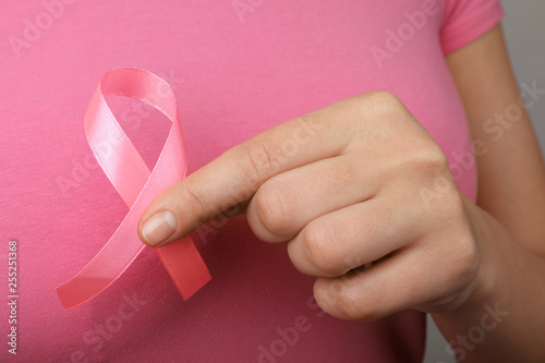 Woman holding pink ribbon, closeup. Breast cancer awareness