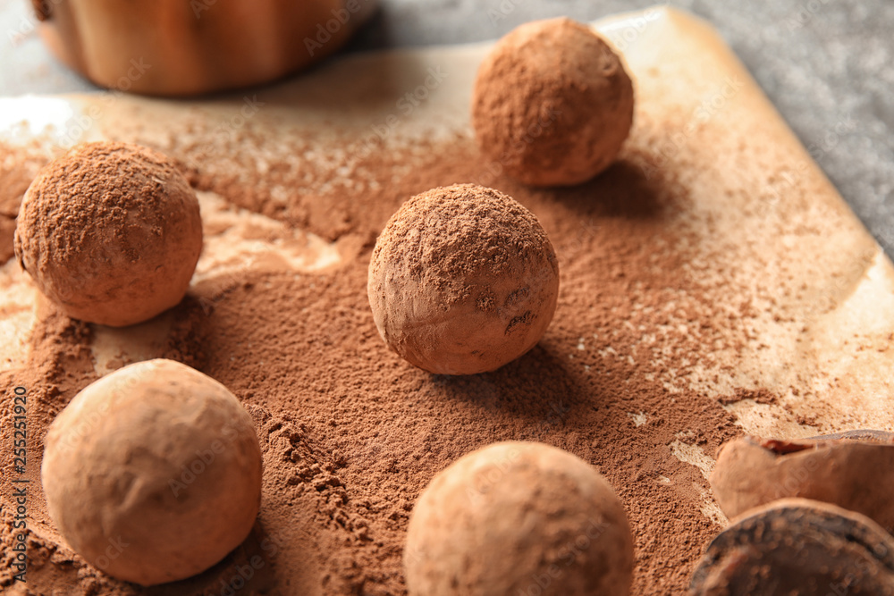 Sweet chocolate truffles powdered with cacao on parchment paper Sweet chocolate truffles powdered with cacao on parchment paper