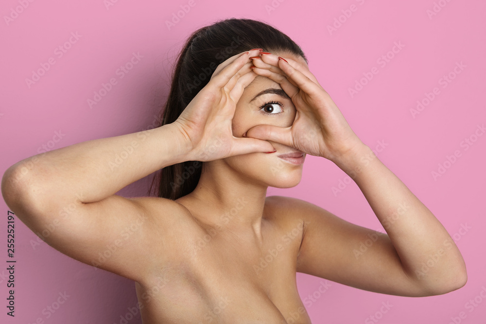 Portrait of beautiful pretty young woman with long hair looking at the camera at empty pink background wall. Space for copy paste text message Portrait of beautiful pretty young woman with long hair looking at the camera at empty pink background wall. Space for copy paste text message