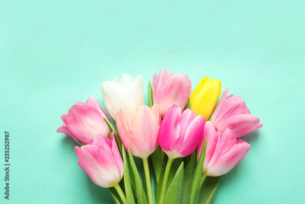 Spring tulips on color background, top view. International Women's Day