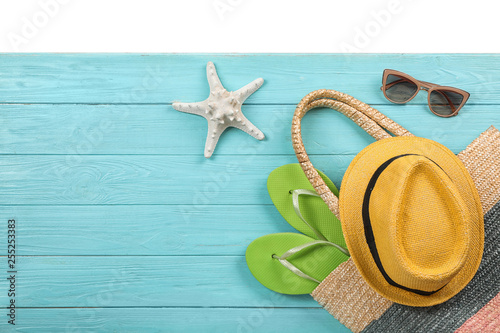 Flat lay composition with beach accessories on wooden background. Space for text