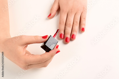 Woman applying nail polish on white background  closeup