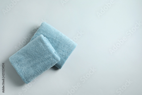 Fresh fluffy folded towels on grey background, top view. Space for text