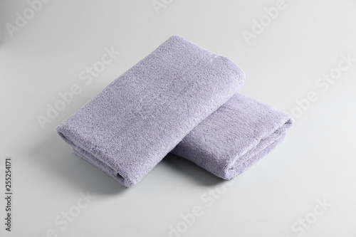 Fresh fluffy folded towels on grey background