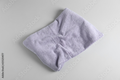 Fresh fluffy towel on grey background, top view