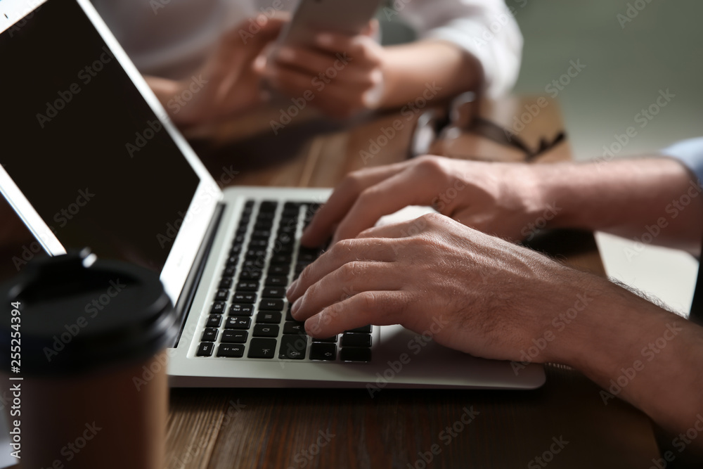 Businessman working on laptop in office, closeup. Professional communication