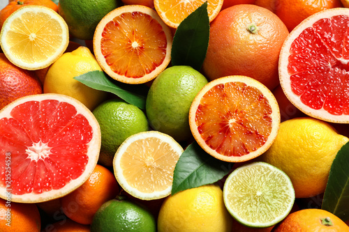 Different citrus fruits as background  top view