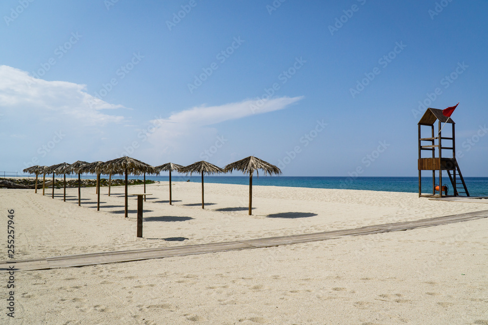Sonnenschirme und Rettungsturm auf Sandstrand Sonnenschirme und Rettungsturm auf Sandstrand