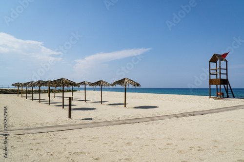 Sonnenschirme und Rettungsturm auf Sandstrand