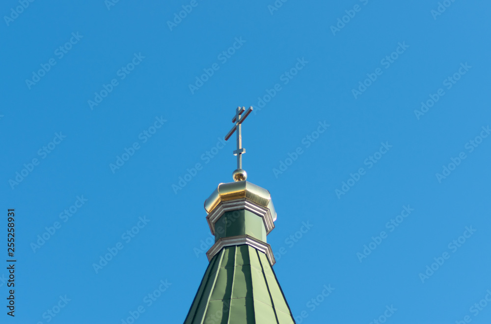 a gold dome with a cross against the sky. Orthodox cross in the blue sky. Christianity. Religion. Orthodox Christianity. Jesus. Easter. a gold dome with a cross against the sky. Orthodox cross in the blue sky. Christianity. Religion. Orthodox Christianity. Jesus. Easter.