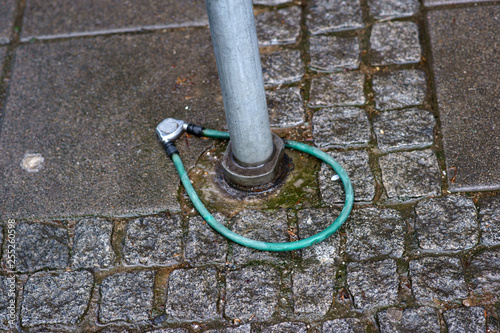 Ein liegengelassenes und um den Halter eines geschlossenes Fahrradschloss. ... photo