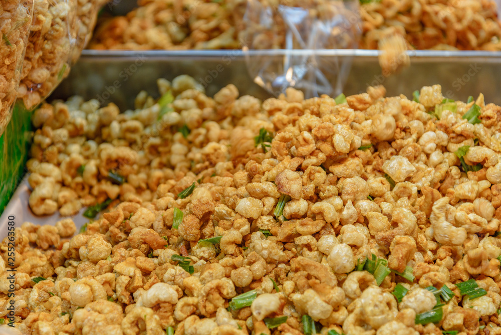 Pile of deep fried or bake pork snack, pork rind, pork scratching or pork crackling on the tray in a market. Pile of deep fried or bake pork snack, pork rind, pork scratching or pork crackling on the tray in a market.