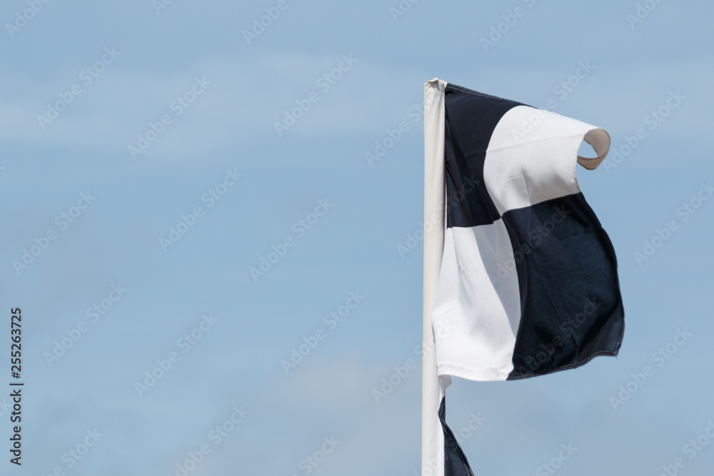 Black and white flags erected by lifeguards (beach patrol) marking the